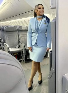 a woman in a blue suit standing on an airplane