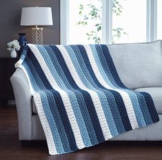 a couch with a blue and white blanket on it