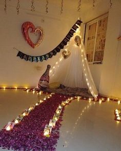 a room decorated with candles and flowers in the shape of a triangle on the floor