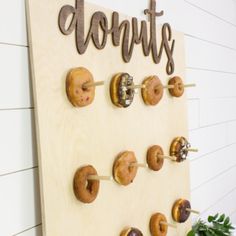 doughnuts are mounted to the side of a wooden board that says donuts