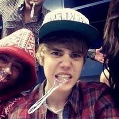 a group of young people standing next to each other with toothbrushes in their mouths