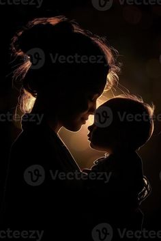 a woman holding a baby in her arms with the light shining on her face behind her