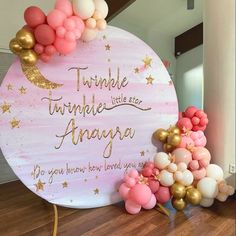 there is a sign that says twinkle the moon and balloons in front of it on the floor