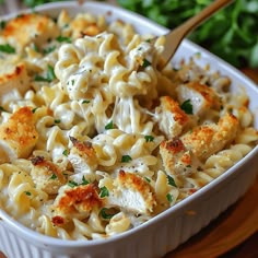 a white dish filled with macaroni and cheese on top of a wooden table