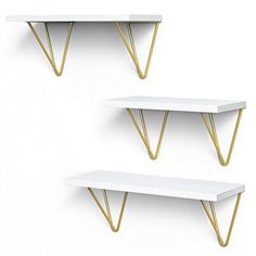 three white shelves with gold legs on each shelf