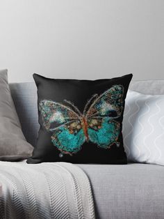 a blue butterfly sitting on top of a couch with its wings spread out throw pillow