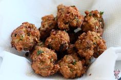 a basket filled with meatballs on top of a white cloth covered in seasoning