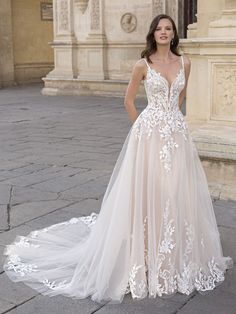 a woman standing in front of a building wearing a wedding dress