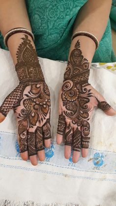 two hands with henna designs on them