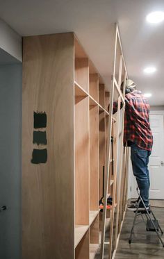 a man standing on a ladder in front of some shelves