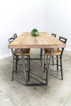 a wooden table with chairs around it and a plant on top of the dining room table