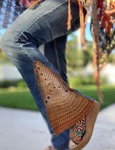 a woman in jeans and sandals is swinging on a rope with her handmade purse