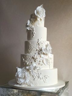 a three tiered wedding cake with white flowers