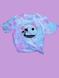 a tie dye shirt with a palm tree on the front and sunset in the back