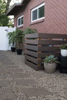 several potted plants in front of a house