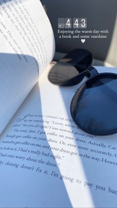 an open book with sunglasses on top of it