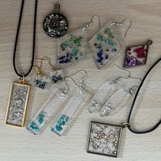 several different necklaces and pendants on a table