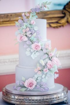 a white wedding cake with pink and purple flowers