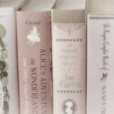 three books are lined up on a shelf in a library, one is pink and the other is white