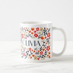 a white coffee mug with flowers and the word cliva on it's side