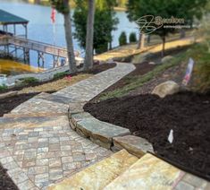 a stone path leading to a dock on the water