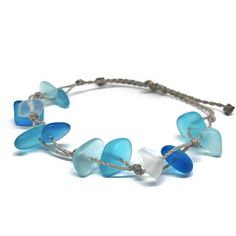 Channel your inner mermaid with this gorgeous beach bracelet or anklet made with mixed blues and white sea glass pebbles on our durable hand spun rope cord. Pure island style! Easy and secure adjustable slide knot closure allows for easy on and off. This bracelet/anklet is completely waterproof and metal free making it perfect for anyone with skin sensitivities and is a wonderful and unique gift for those hard to shop for friends and family on your list, especially the beach lovers! Color: Mixed Adjustable Blue Beachy Jewelry, Blue Adjustable Beachy Jewelry, Beachy Blue Adjustable Jewelry, Adjustable Blue Beach Jewelry, Beach Jewelry Blue Hand-wrapped, Adjustable Blue Jewelry For Beach, Adjustable Blue Jewelry Made Of Recycled Glass, Adjustable Blue Recycled Glass Jewelry, Adjustable Blue Jewelry With Recycled Glass