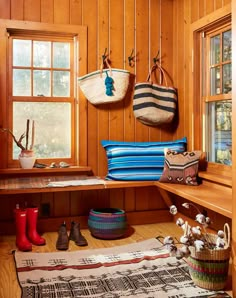 a room with wooden paneling and several baskets hanging on the wall next to a window