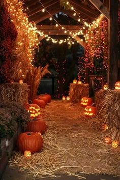 pumpkins and hay bales are lit up in an outdoor area with string lights