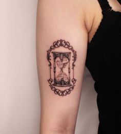 a woman's arm with an hourglass tattoo on the left side of her arm