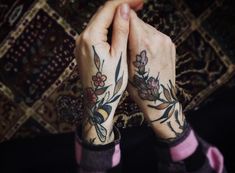 two hands holding each other with tattoos on them