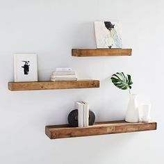 two wooden shelves with books and vases on them