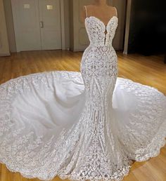 a white wedding dress on a mannequin in the middle of a wooden floor