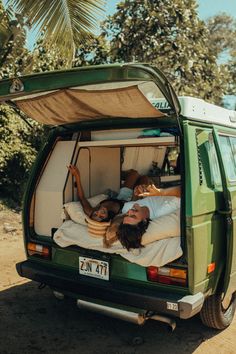 two people laying in the back of a van