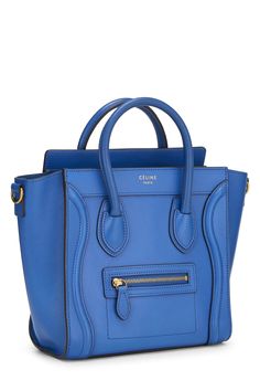 Find CELINE Luggage Nano Bag on Editorialist. The Céline Luggage Nano Bag is crafted from drummed calfskin leather. It features a top handle, a detachable and adjustable shoulder strap, a push lock closure, and a gold-tone hardware. The bag also includes a small pocket at the back and a zipped pocket on the front. Blue Calf Leather Bag With Gold-tone Hardware, Chic Blue Calf Leather Bag, Blue Calf Leather Bag With Detachable Strap, Blue Textured Calf Leather Bag, Blue Luxury Textured Leather Satchel, Luxury Blue Textured Leather Satchel, Tas Celine, Celine Nano Luggage, Celine Luggage