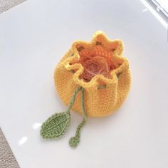 a small crocheted bag with a flower in it