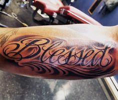 a man's arm with the word blessing tattooed on it