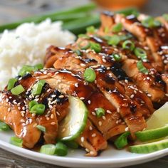 a white plate topped with chicken, rice and cucumber next to green beans