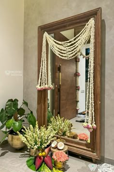 a mirror sitting on top of a table next to flowers and other decorating items