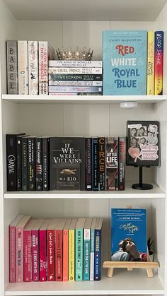 a book shelf filled with lots of books on top of white shelves next to each other