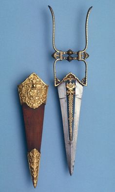 two pieces of metal and wood on a blue background, one with an elaborate handle