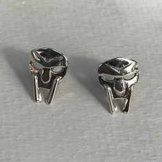 Custom made MF DOOM earrings, made from 100% recycled sterling silver. These are friction posts, and come with the matching backs.  This item is custom made to order. That means it may take an extra second or two to make your entire piece by hand. We try to beat shipping estimates, but its just a one woman team in this shop! Our supplier of casting grain uses SCS-certified 100% recycled metal. We make everything in house to order, from start to finish. After you place your order, a model is grow Symbolic Silver Tarnish Resistant Earrings, Symbolic Silver Tarnish-resistant Earrings, Symbolic Tarnish-resistant Silver Earrings, Mf Doom, Earring Studs, Matching Jewelry, Metal Accessories, Custom Earrings, Rap Music