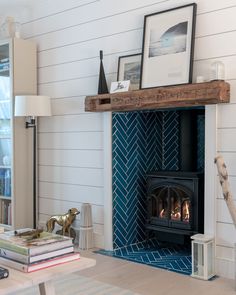 a living room with a fireplace and pictures on the wall next to bookshelves