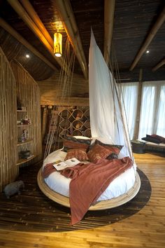 a bed that is in the middle of a room with wood flooring and walls