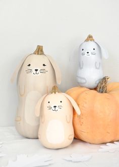 three small pumpkins are sitting next to each other