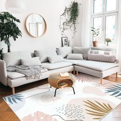 a living room filled with furniture and a large mirror on the wall above it's windows