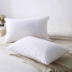 two white pillows sitting on top of a bed