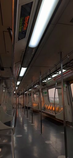 the inside of a subway train with lights on and no people in it at all