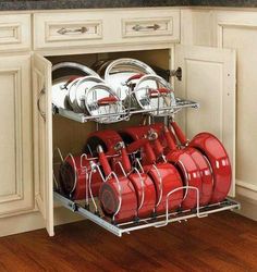 an open dish rack with many pots and pans on it in a white kitchen