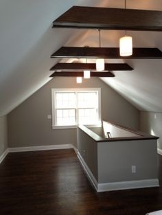 an empty loft with wood floors and white walls