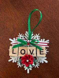 a christmas ornament with the word love spelled on it and a poinsetti